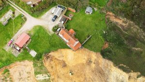 aerial photo of farmhouse on edge of cliff SWNS