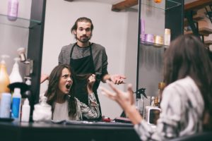 woman mirror unhappy haircut stylist